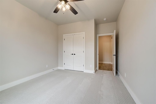 unfurnished bedroom featuring light colored carpet, a closet, and ceiling fan