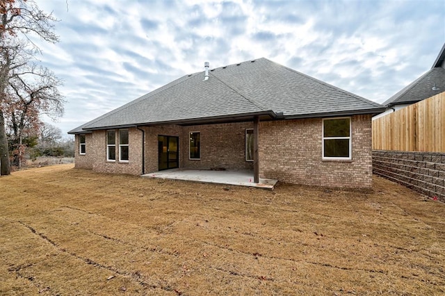 rear view of house with a patio area and a lawn