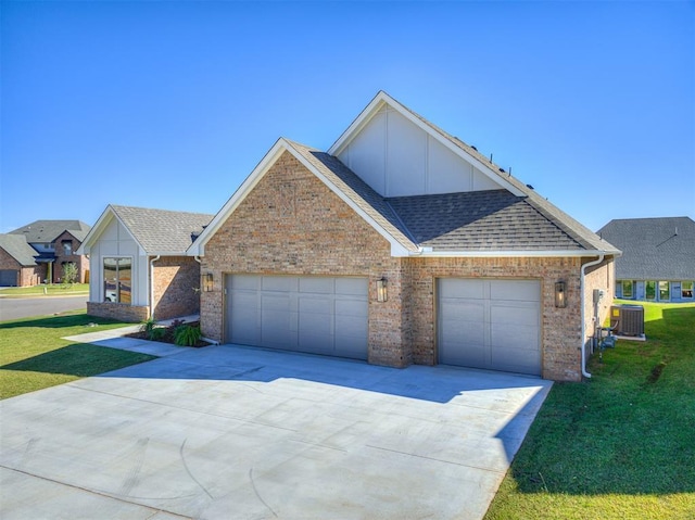 view of front facade with a garage, central air condition unit, and a front lawn