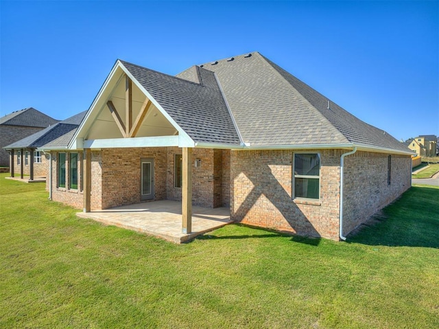 rear view of property with a lawn and a patio