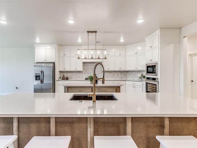 kitchen with sink, stainless steel appliances, and a large island with sink