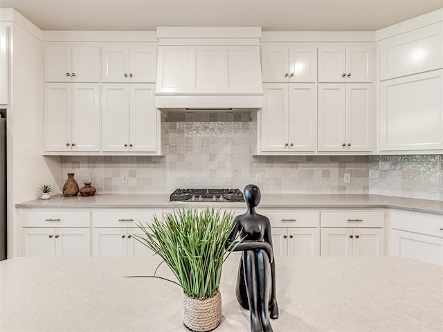 kitchen with premium range hood, white cabinetry, and tasteful backsplash