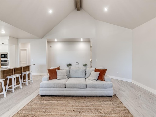 living room with beamed ceiling, light hardwood / wood-style floors, and high vaulted ceiling