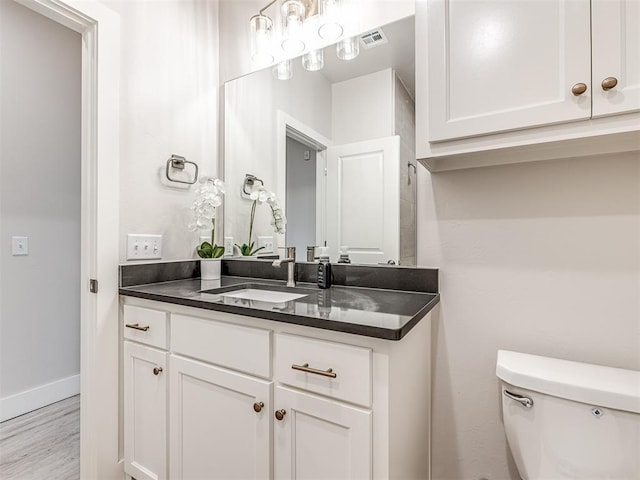 bathroom with wood-type flooring, toilet, and vanity