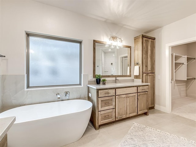 bathroom featuring a tub to relax in, tile patterned flooring, and vanity