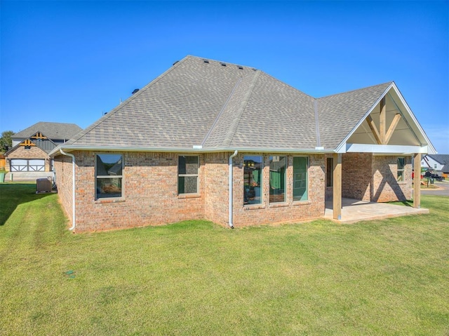 back of house with central air condition unit, a patio, and a yard