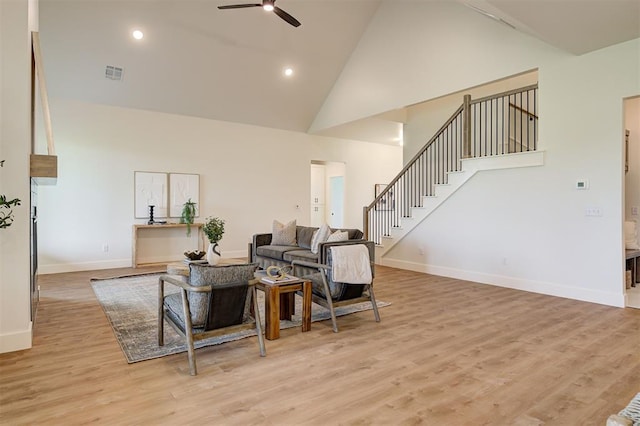 living room featuring high vaulted ceiling, ceiling fan, and light wood-type flooring