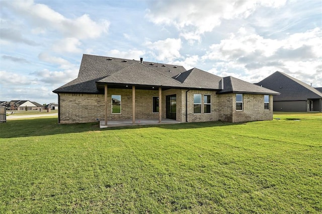 rear view of property with a yard and a patio