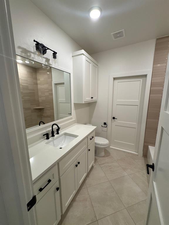 bathroom with vanity, tile patterned floors, and toilet