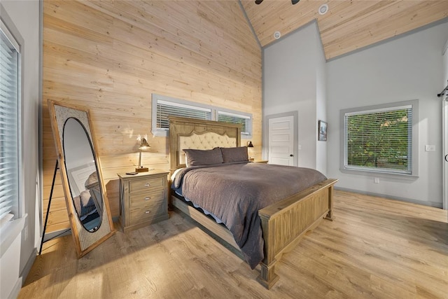 bedroom featuring high vaulted ceiling, wooden ceiling, wood walls, and light wood-type flooring