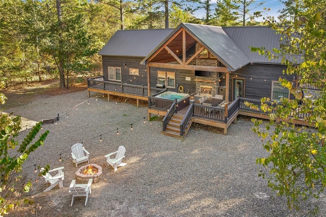 rear view of house with a patio area, a deck, an outdoor fire pit, and a fireplace