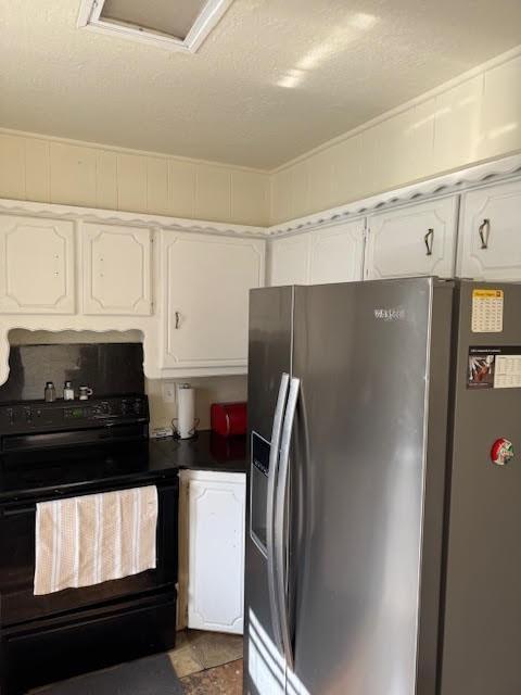 kitchen featuring black / electric stove, dark countertops, white cabinetry, and stainless steel fridge with ice dispenser