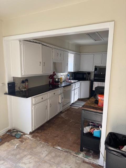 kitchen featuring black microwave, a sink, white cabinetry, dishwasher, and dark countertops