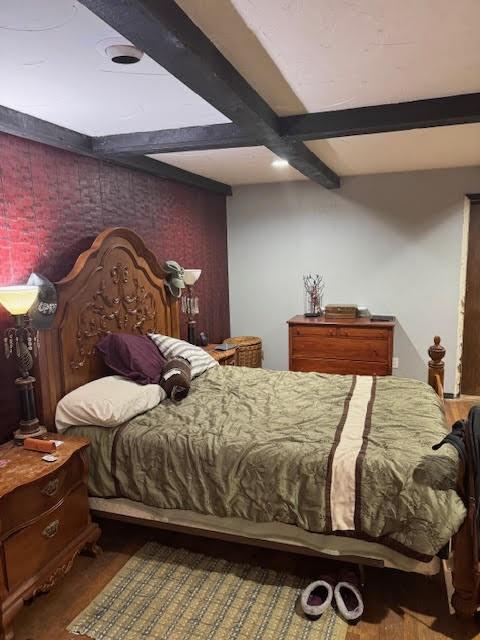 bedroom with hardwood / wood-style flooring and beamed ceiling