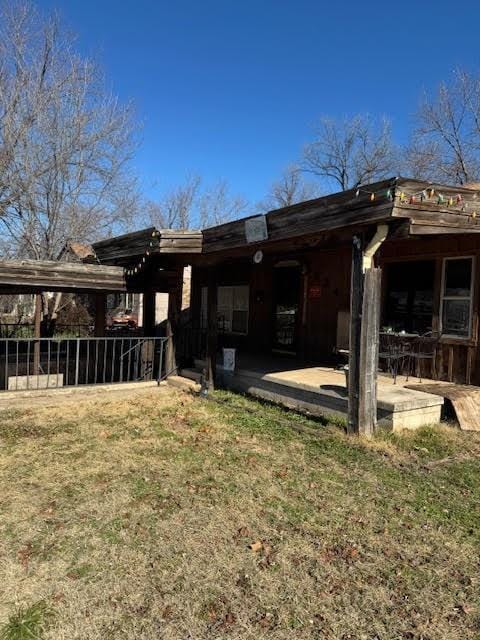 back of house featuring a patio area and a lawn