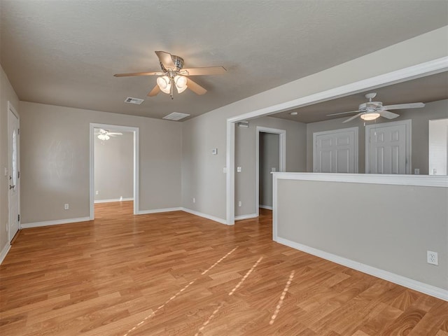 unfurnished room with ceiling fan and light wood-type flooring