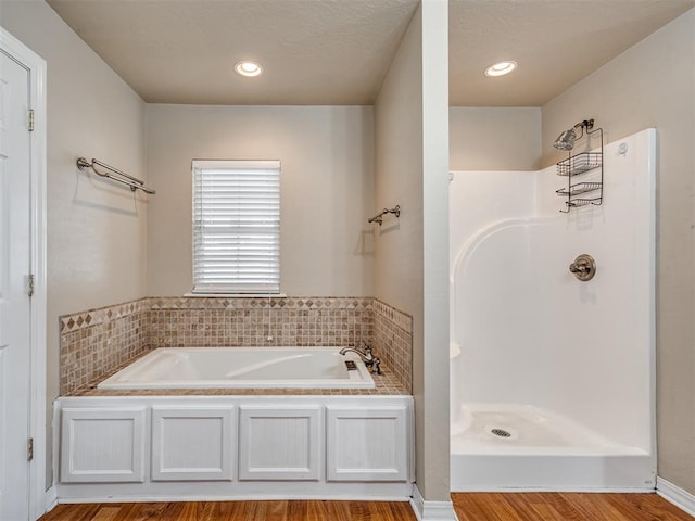 bathroom featuring wood-type flooring and separate shower and tub