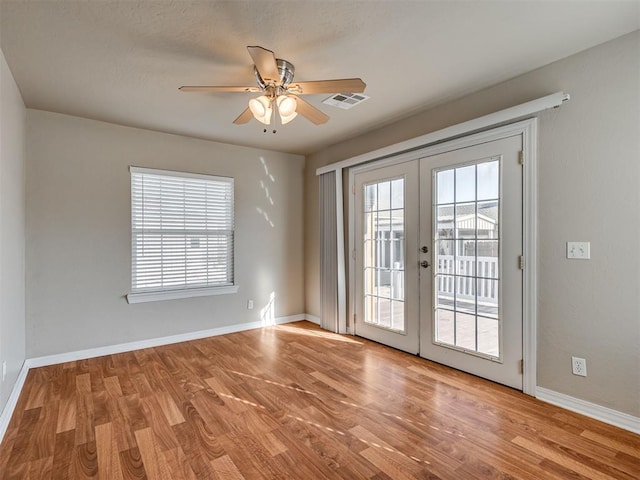 spare room featuring french doors, ceiling fan, and hardwood / wood-style flooring