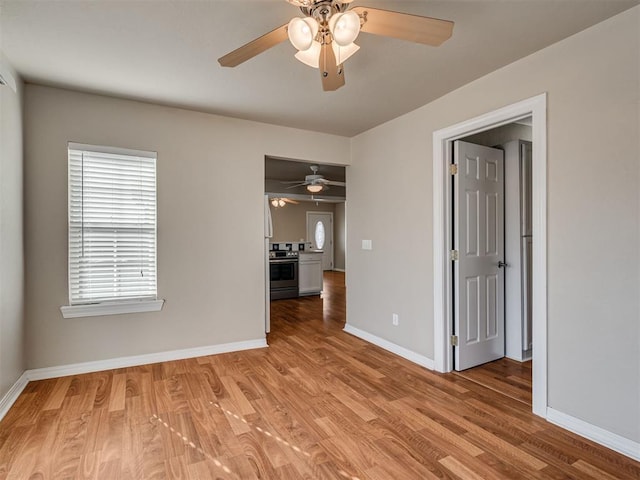 empty room with ceiling fan and light wood-type flooring