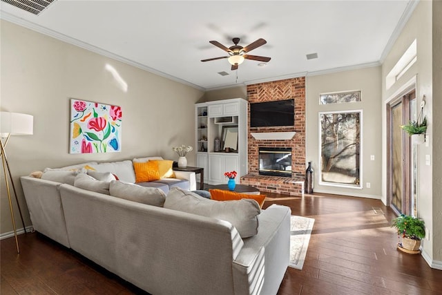 living room featuring dark hardwood / wood-style flooring, crown molding, a fireplace, and ceiling fan