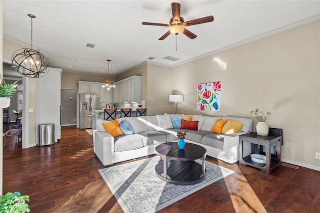 living room featuring ornamental molding, dark hardwood / wood-style floors, and ceiling fan with notable chandelier