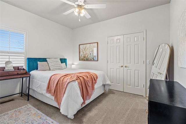 bedroom with a closet, ceiling fan, and carpet flooring