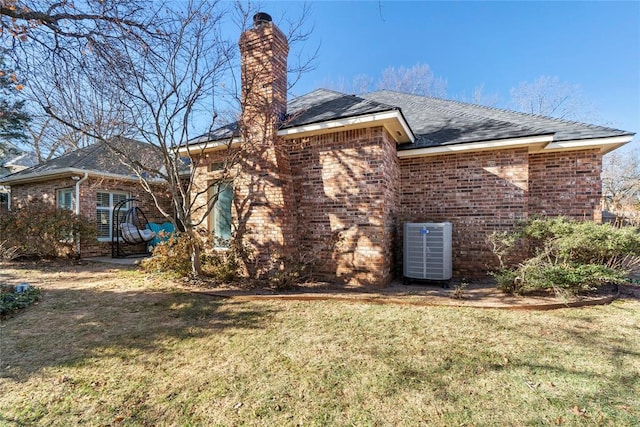 back of house featuring central AC and a yard