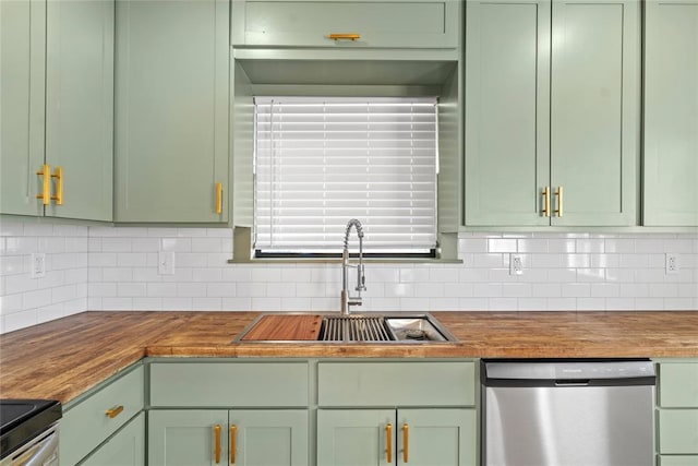 kitchen featuring sink, green cabinets, butcher block counters, appliances with stainless steel finishes, and tasteful backsplash