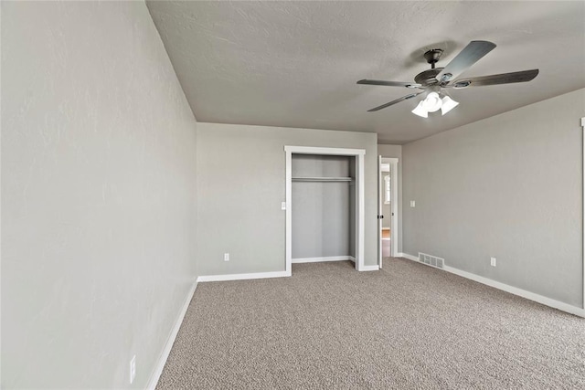 unfurnished bedroom with ceiling fan, carpet floors, and a textured ceiling