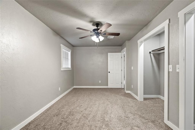 unfurnished bedroom featuring a closet, ceiling fan, light colored carpet, and a textured ceiling