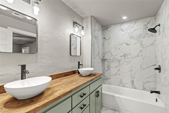 bathroom with tiled shower / bath combo and vanity