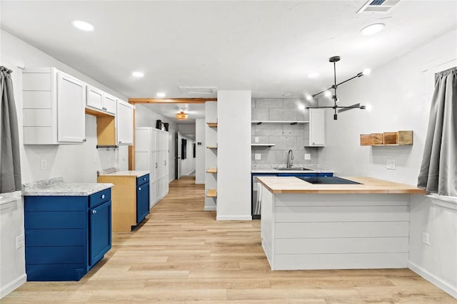 kitchen with wooden counters, sink, white cabinetry, black electric stovetop, and blue cabinets