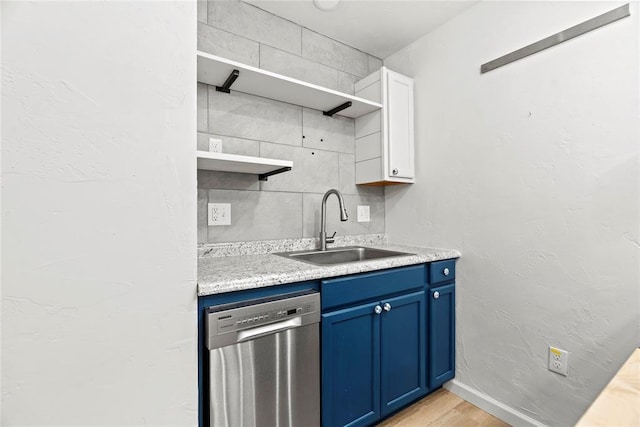 kitchen featuring blue cabinetry, white cabinetry, stainless steel dishwasher, sink, and light wood-type flooring