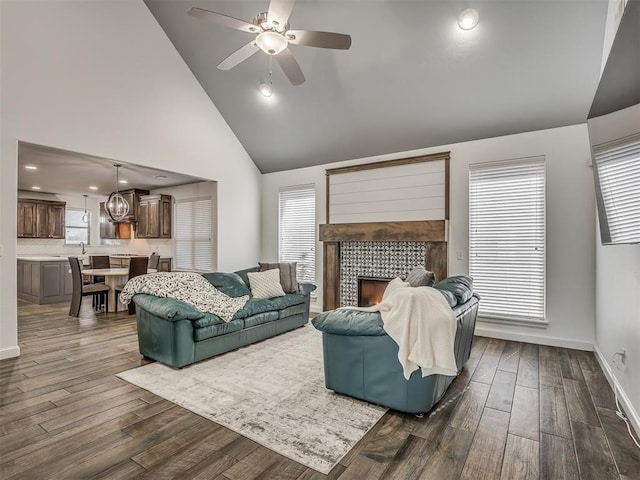 living room featuring a healthy amount of sunlight, a tiled fireplace, and dark hardwood / wood-style flooring