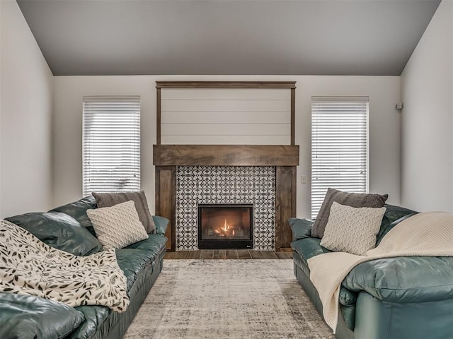 living room featuring a tile fireplace and light hardwood / wood-style floors