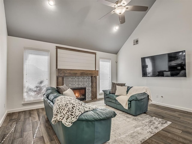 living room with lofted ceiling, a healthy amount of sunlight, dark hardwood / wood-style flooring, and a fireplace