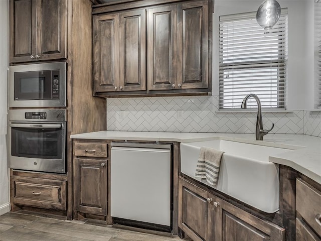 kitchen featuring stainless steel appliances, hardwood / wood-style flooring, dark brown cabinetry, and sink