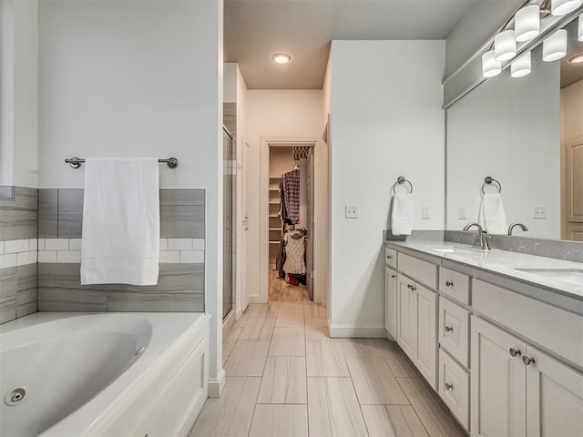 bathroom with vanity and shower with separate bathtub