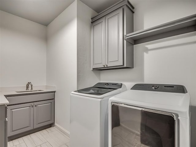 washroom with washing machine and dryer, sink, and cabinets