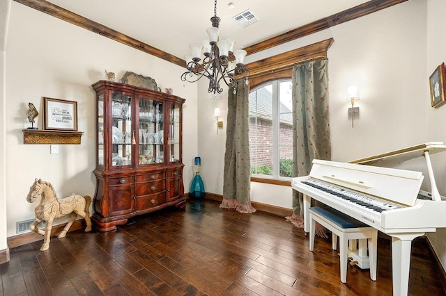 living area featuring baseboards, visible vents, hardwood / wood-style flooring, crown molding, and a chandelier