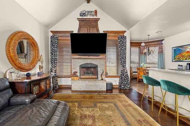 living room featuring lofted ceiling, dark wood-type flooring, and a fireplace