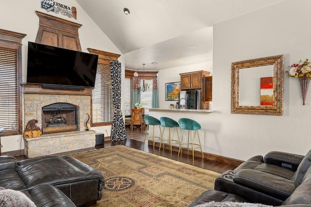 living room featuring baseboards, lofted ceiling, a stone fireplace, and dark wood-style floors