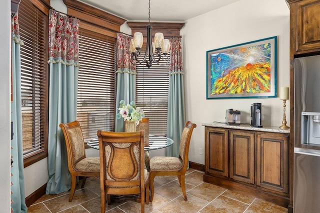 dining area featuring a healthy amount of sunlight, baseboards, and a chandelier