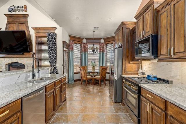 kitchen with visible vents, backsplash, light stone countertops, appliances with stainless steel finishes, and a sink