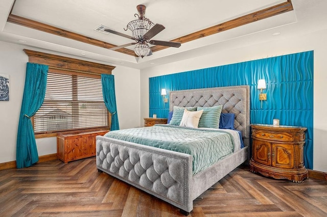 bedroom with a ceiling fan, a tray ceiling, baseboards, and visible vents