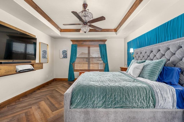 bedroom featuring a tray ceiling, a ceiling fan, baseboards, and ornamental molding