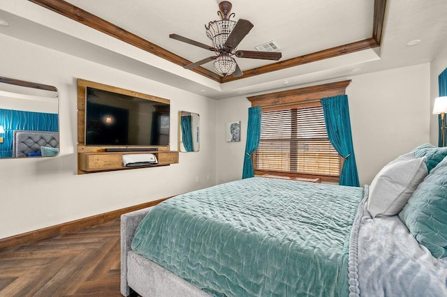 bedroom with a raised ceiling, baseboards, visible vents, and ceiling fan