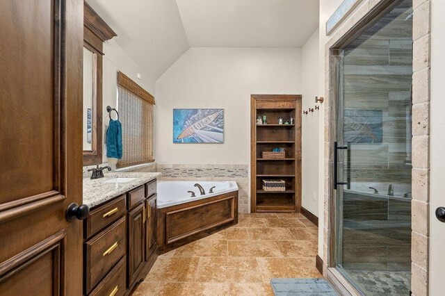 full bathroom featuring a stall shower, vanity, lofted ceiling, and a garden tub