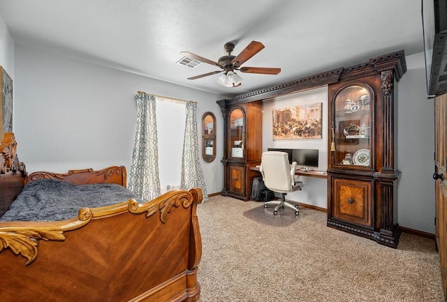 carpeted bedroom featuring visible vents, built in study area, baseboards, and a ceiling fan