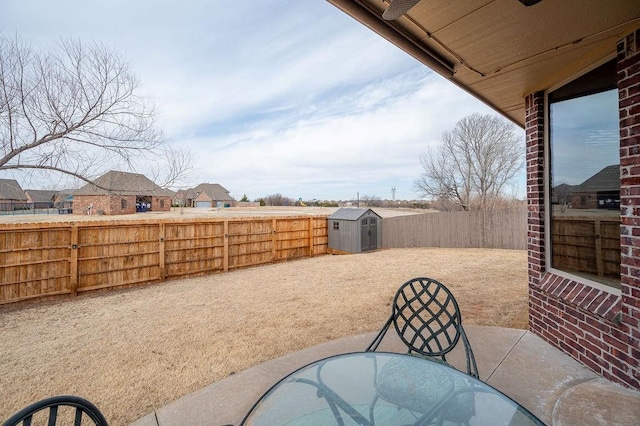 view of patio with an outbuilding, outdoor dining space, a storage shed, and a fenced backyard